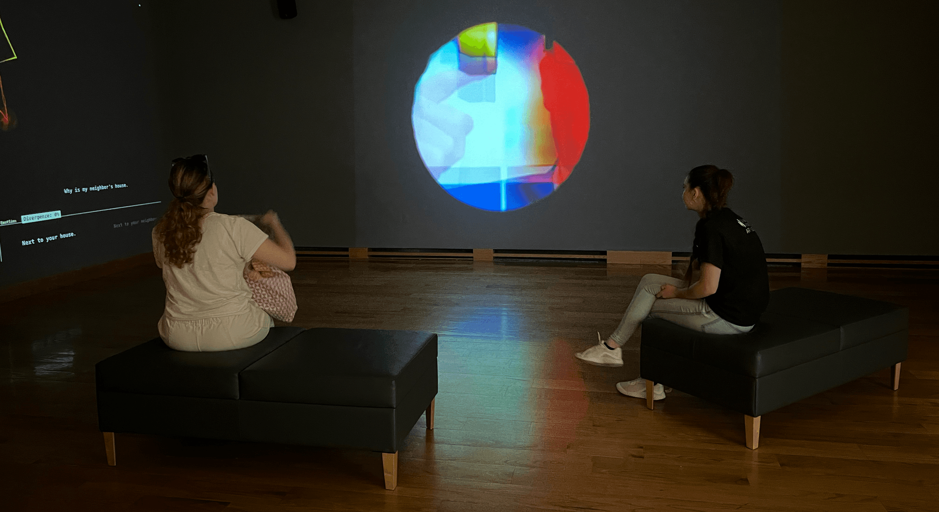 Two visitors watching the main projection, now just a small circle